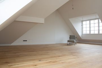 Werkstück - Handwerk und Bau - Referenzen - Dachgeschoss-Sanierung – Heller Raum mit Holzboden und Sessel