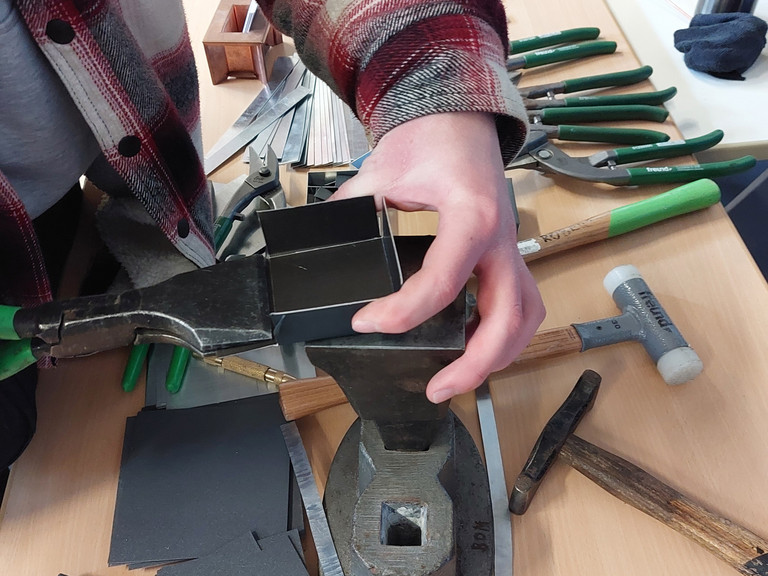 Besucher am Messestand von Werkstück stellt Metallschachtel her