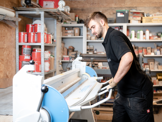 Auszubildender arbeitet an einer Maschine Auszubildender arbeitet an einer Maschine