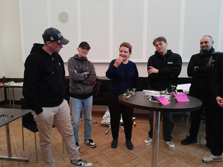 Fünf Personen stehen nebeneinander bei einer Diskussion in einem Veranstaltungsraum beim Teamtag vom Meisterbetrieb für Handwerk Werkstück Berlin zum Thema "Gute Kommunikation verbindet" in Berlin-Wannsee