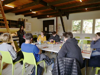 Gruppe Auszubildender diskutiert bei Azubi-Tag an einem Tisch mit Ausbildungskoordinatorin Jessica Paul und Personalentwicklerin Andrea Bogdan im Bootshaus am Wannsee